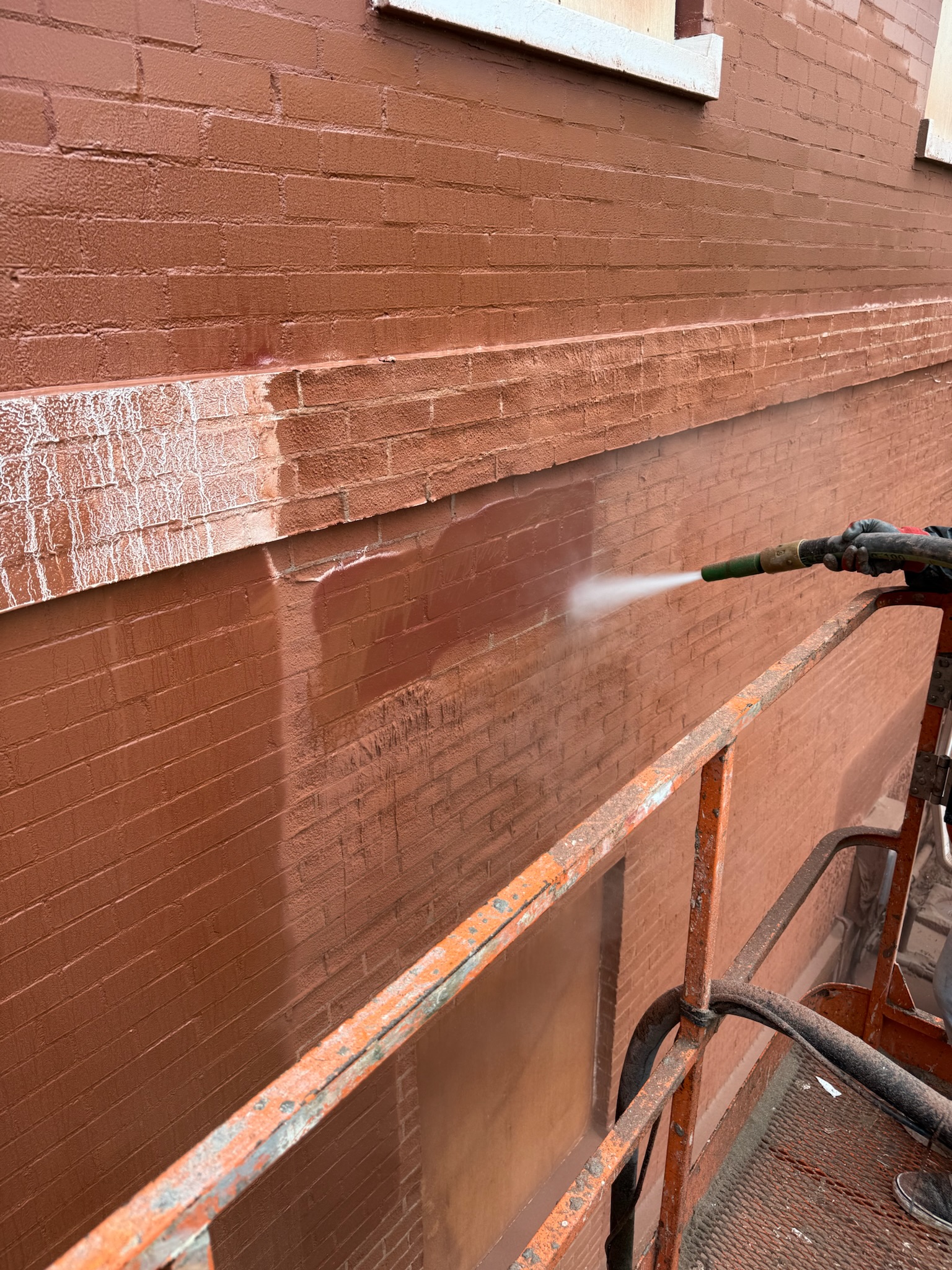 Commercial brick building sandblasting from scaffold